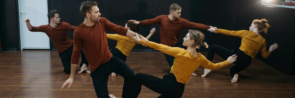 Group of men practicing strength movements in a studio